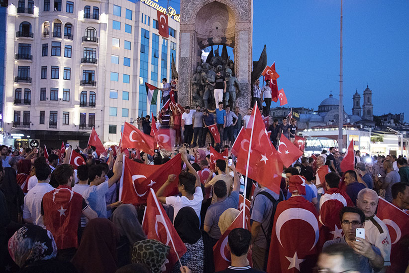 The day after a failed coup attempt in Turkey, supporters of President Recep Tayyip Erdogan and his AK Party gather at Taksim Square for a "Democracy festival", climbing onto the iconic monument of Mustafa Kemal Ataturk, modern Turkey's founder. The fallout from the failed coup has left Turkey more divided than ever between Islamists and secularists. (Photograph by Adnan Khan)