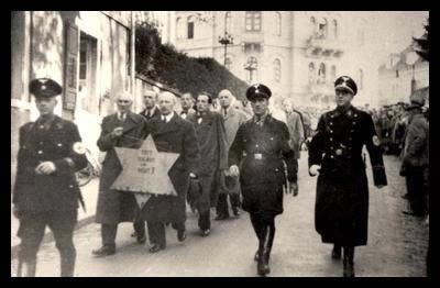 Jews_forced_to_march_with_star_Kristallnacht
